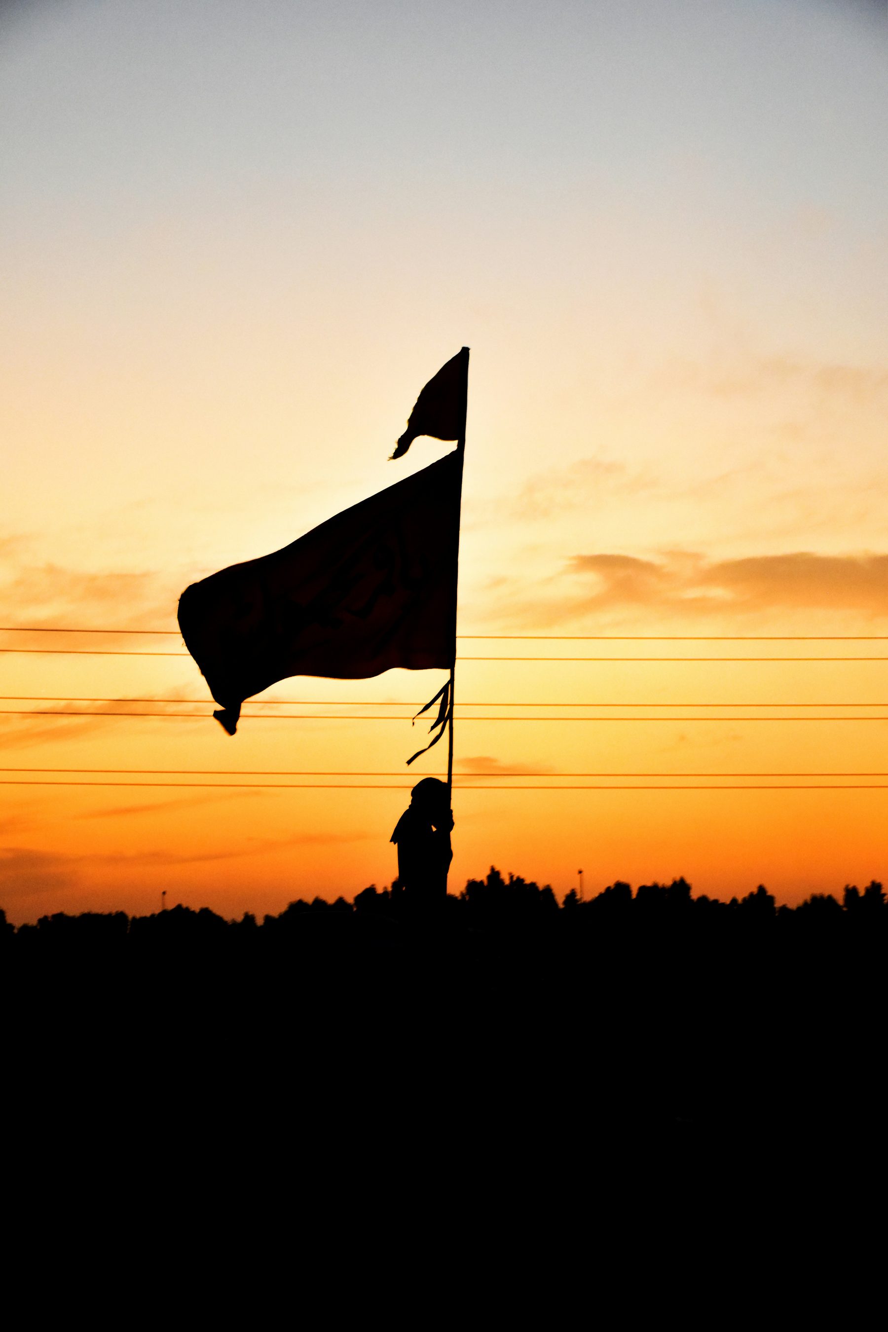 Black flag silhouette against a golden sky